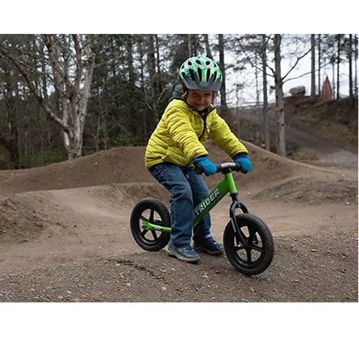 Green balance bike with black wheels and Trider branding suitable for choosing a bike for a 2-year-old